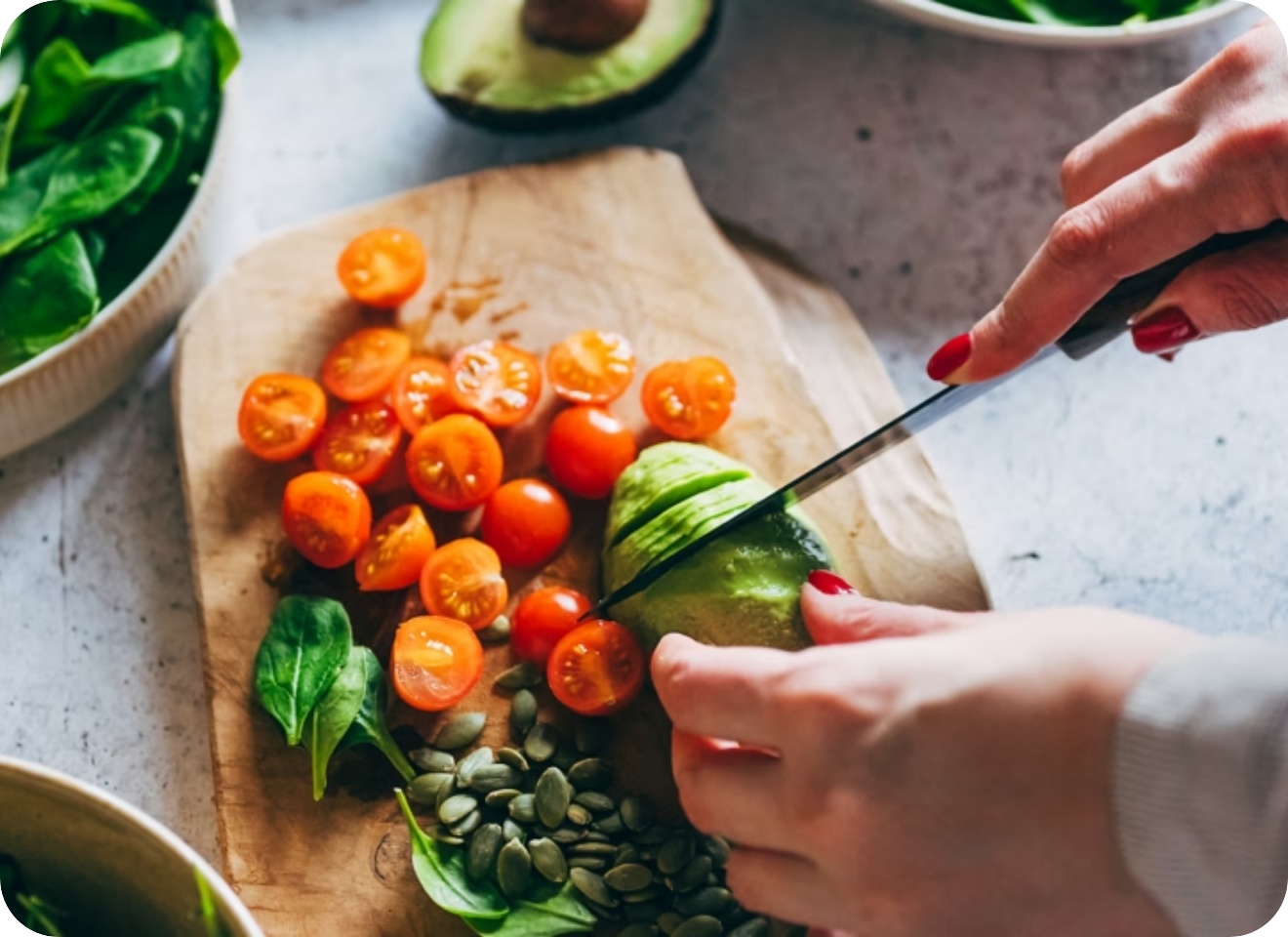 Person schneidet Avocado in Scheiben.