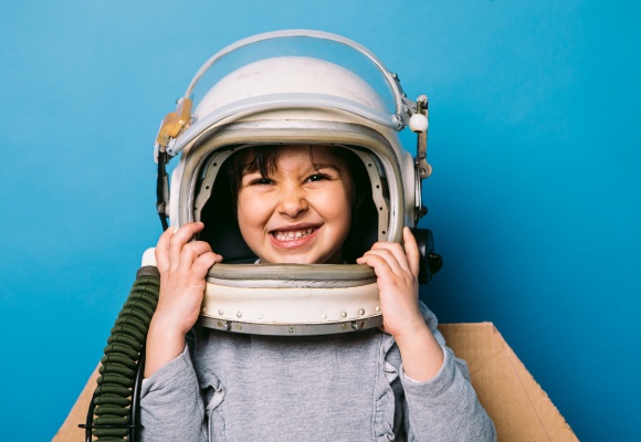 Ein Kind trägt einen Astronautenhelm als Kostüm zum Fasching.