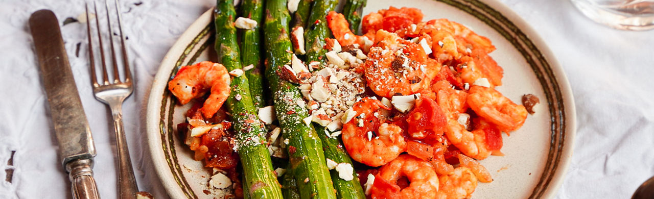 Groene asperges uit de oven met wokgarnalen, tomaat en amandel 
