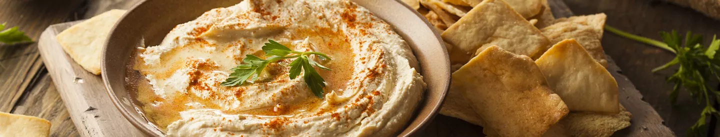 Plato de hummus casero con tostadas de pan de acompañamiento | ALDI Supermercados