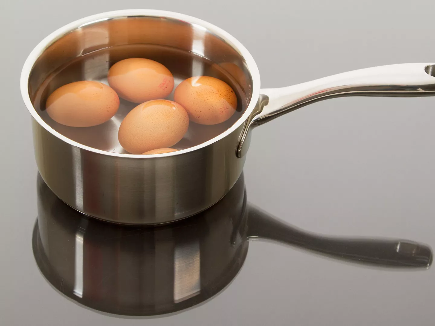 Huevos cocidos sumergidos agua cazo acero inoxidable
