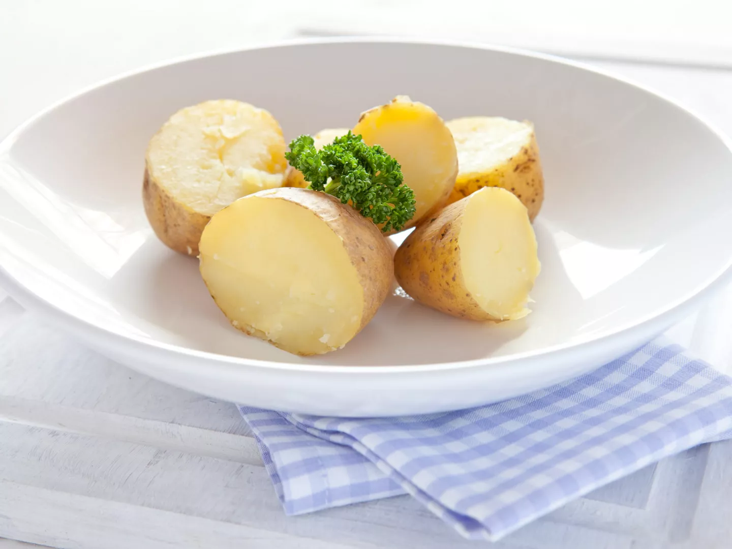 Primer plano plato patatas cocidas cortadas mitad 