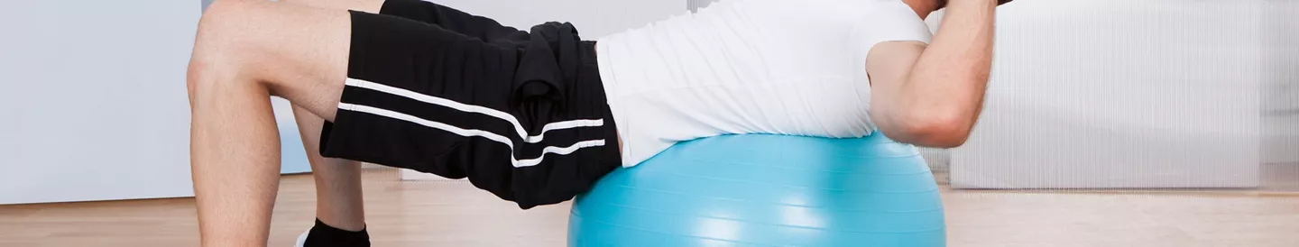 Hombre practicando ejercicios pilates pelota