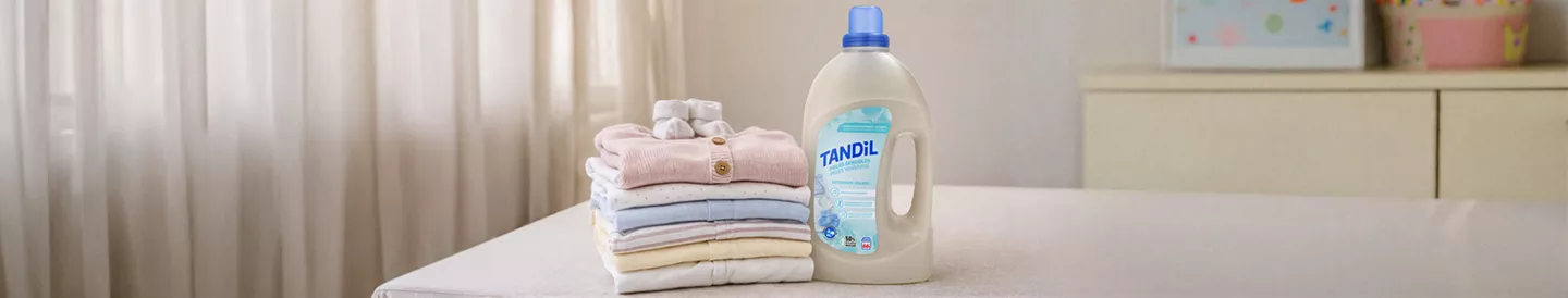 Ropa de bebé doblada junto a detergente Tandil 