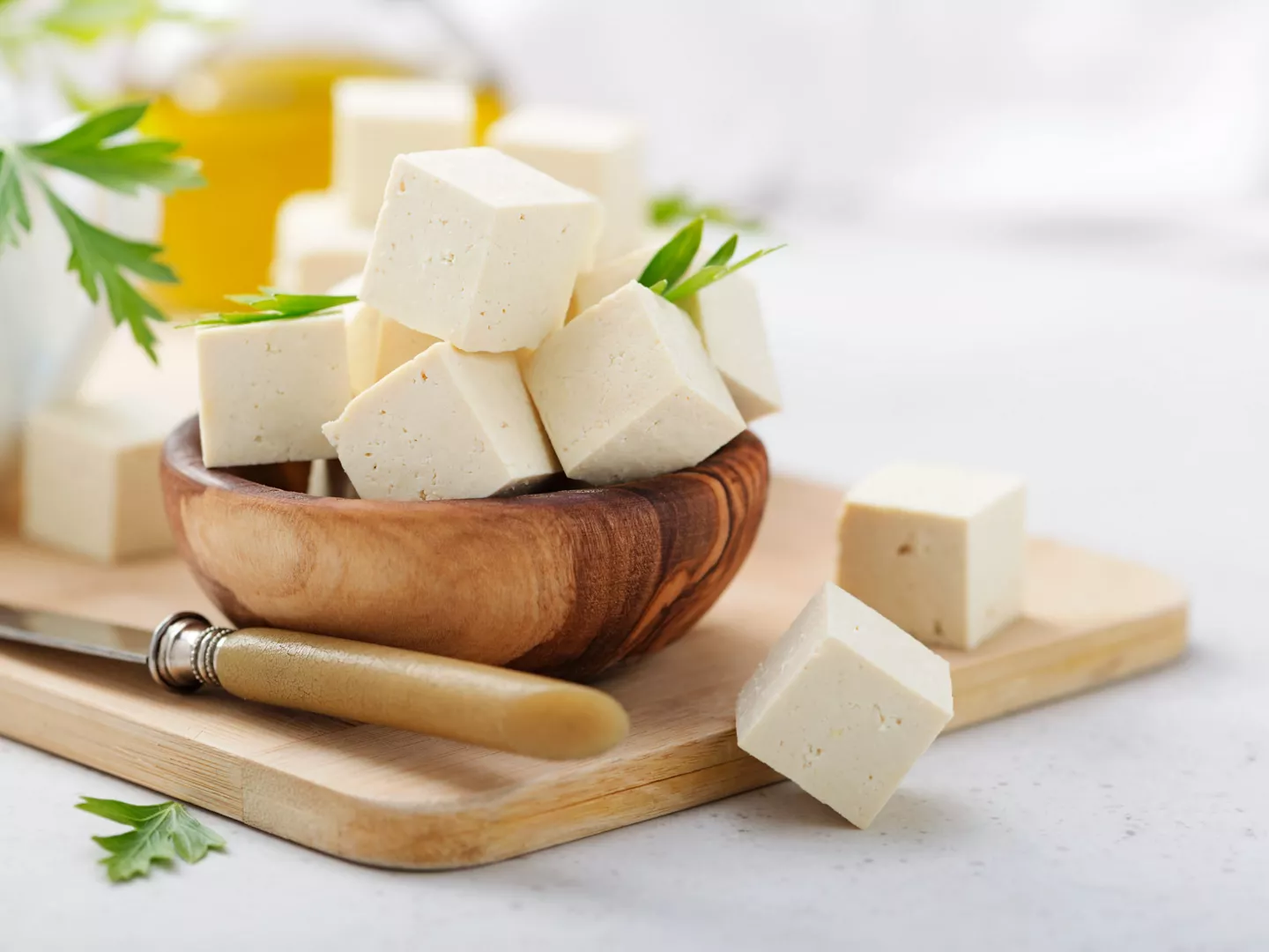 Cuenco dados tofu sobre tabla cortar
