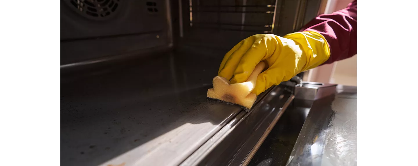 Persona limpiando un horno con bicarbonato de sodio