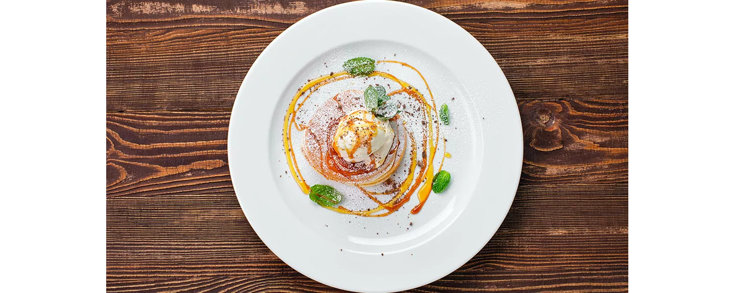 Emplatado de postre con diseño de espiral y hojas de menta