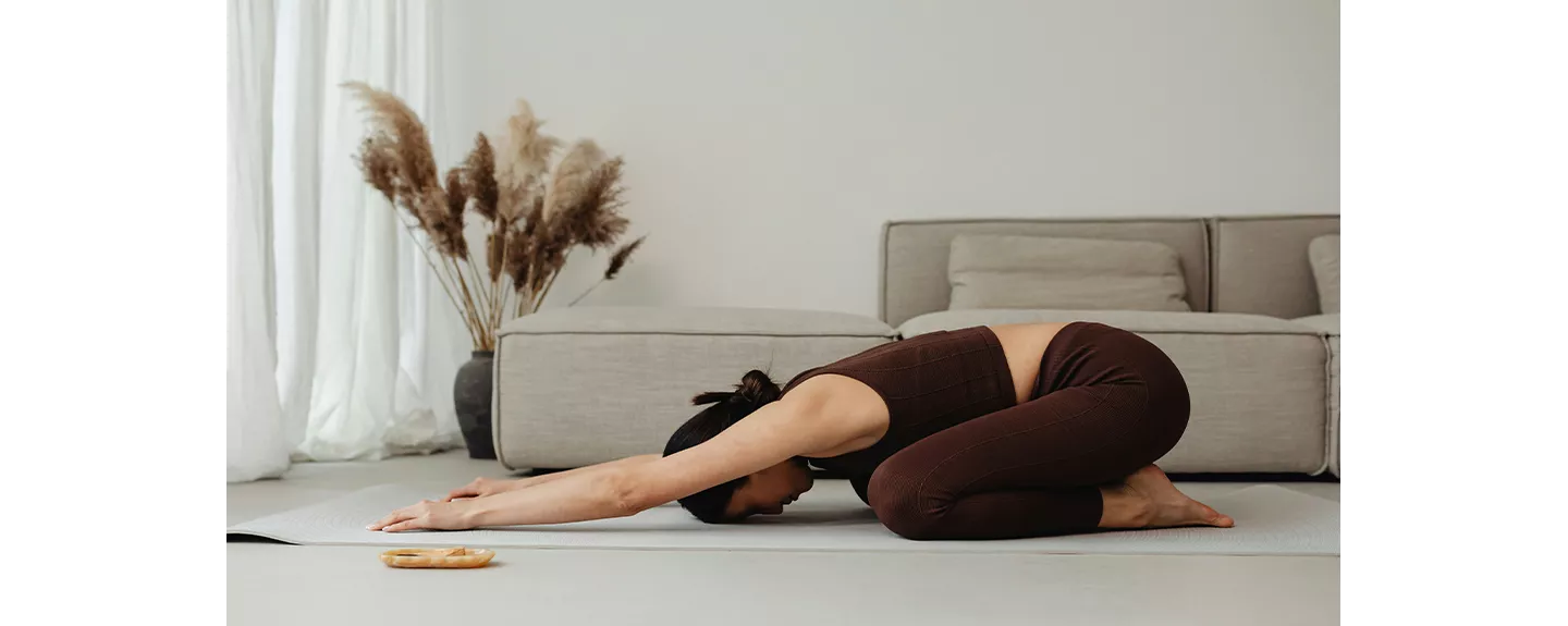 Mujer practicando yoga en casa para mantenerse activa y fortalecer el sistema inmunológico