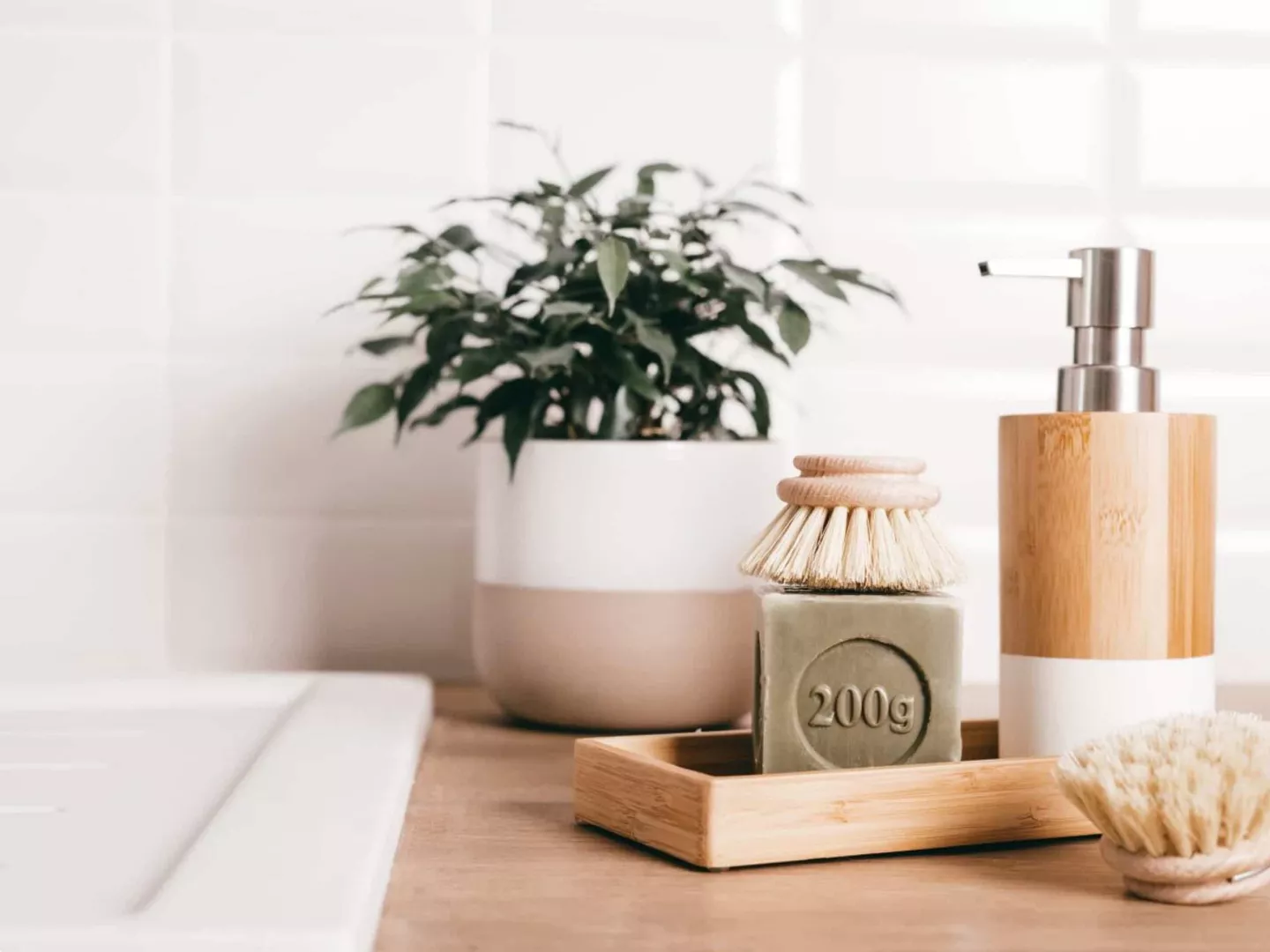 Jabón sólido ecológico con cepillo natural sobre bandeja de madera, en baño de estilo minimalista