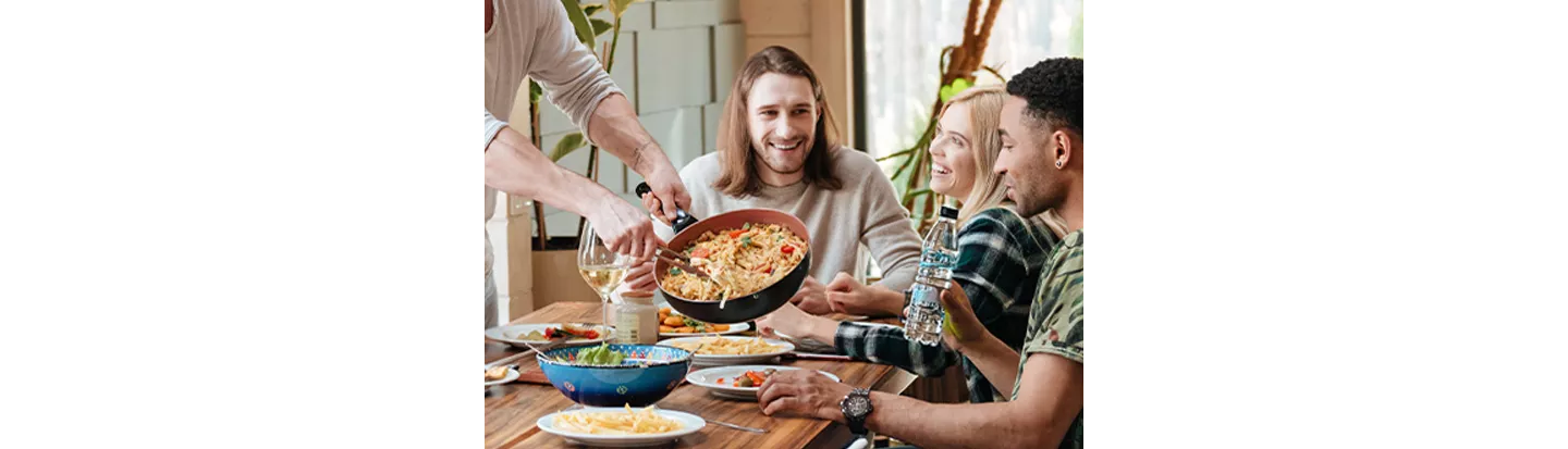 Personas compartiendo pasta con ingredientes frescos en una mesa