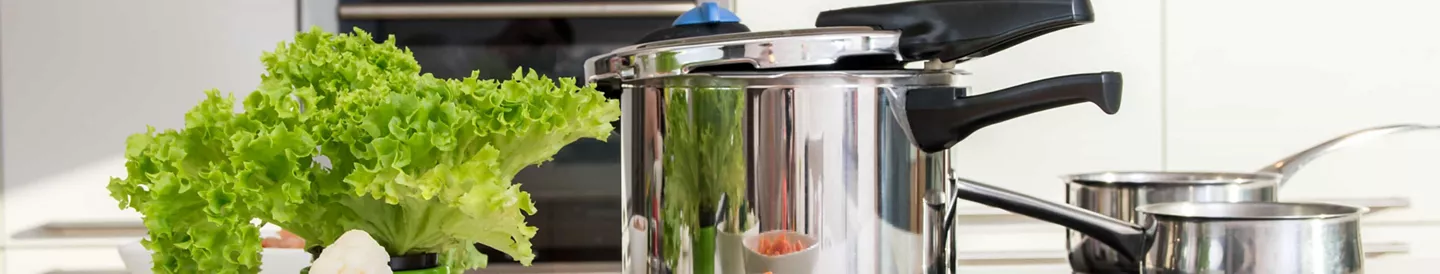 Isla cocina con olla express y hortalizas cocidas 