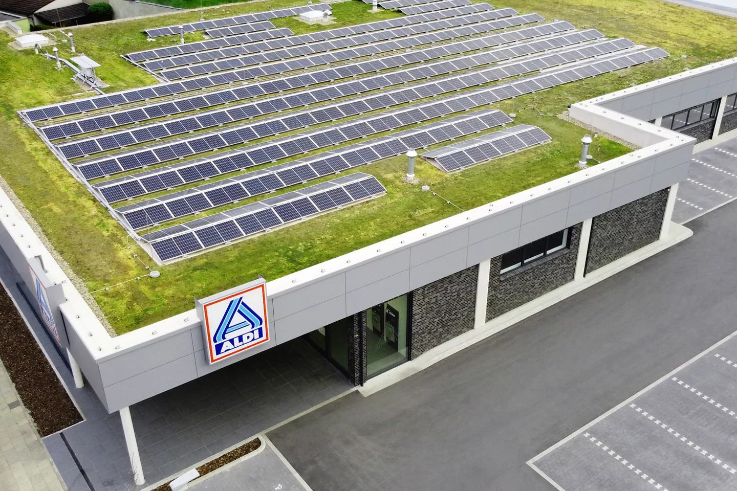 Luftaufnahme eines Gebäudes mit Gründach und Solarpanels; ALDI Logo am Gebäude