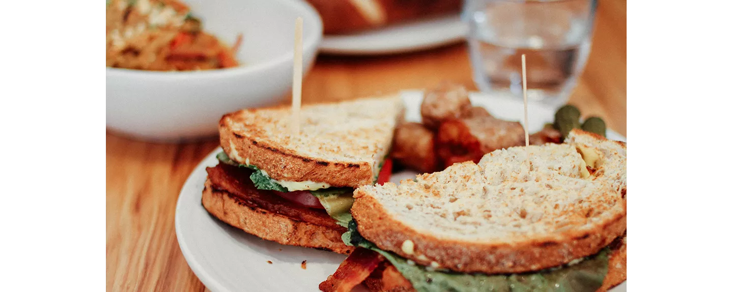 Bocadillo y agua sobre una mesa, almuerzo típico de media mañana
