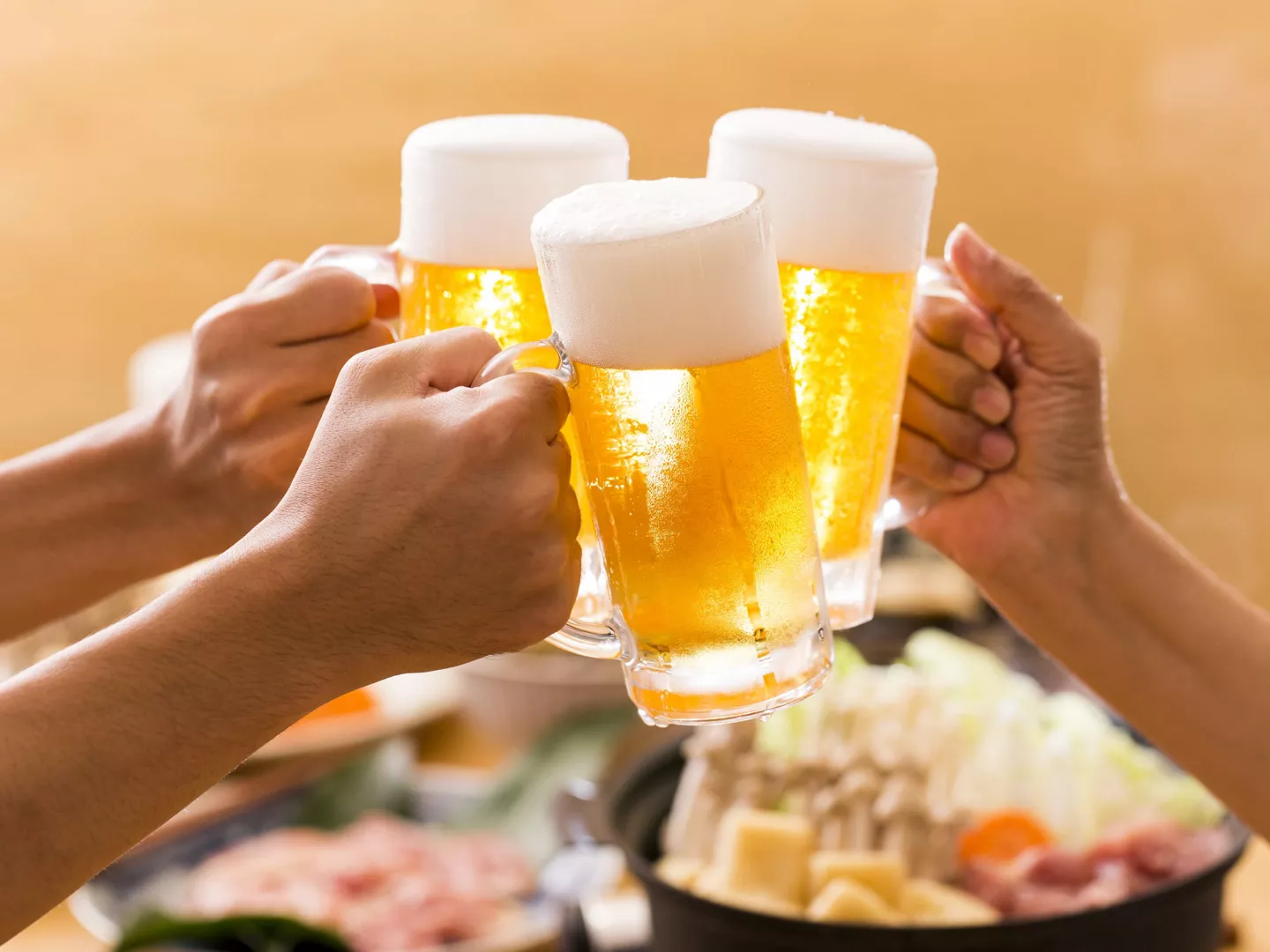 Personas brindando jarras de cerveza