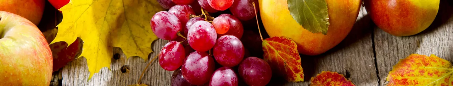 Uvas, peras y manzanas dispuestas encima madera