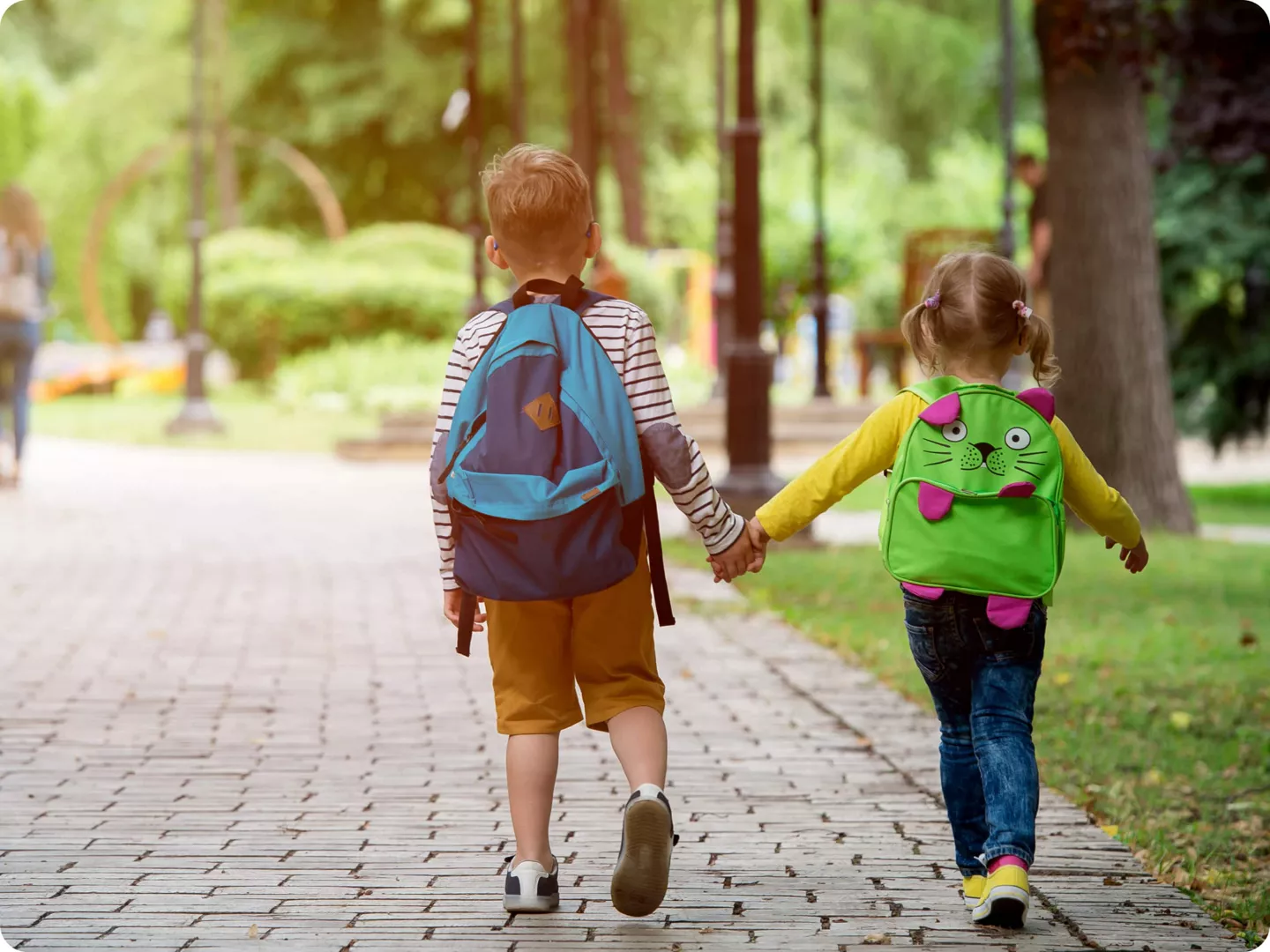 Niño y niña de la mano en su primer día de vuelta al cole