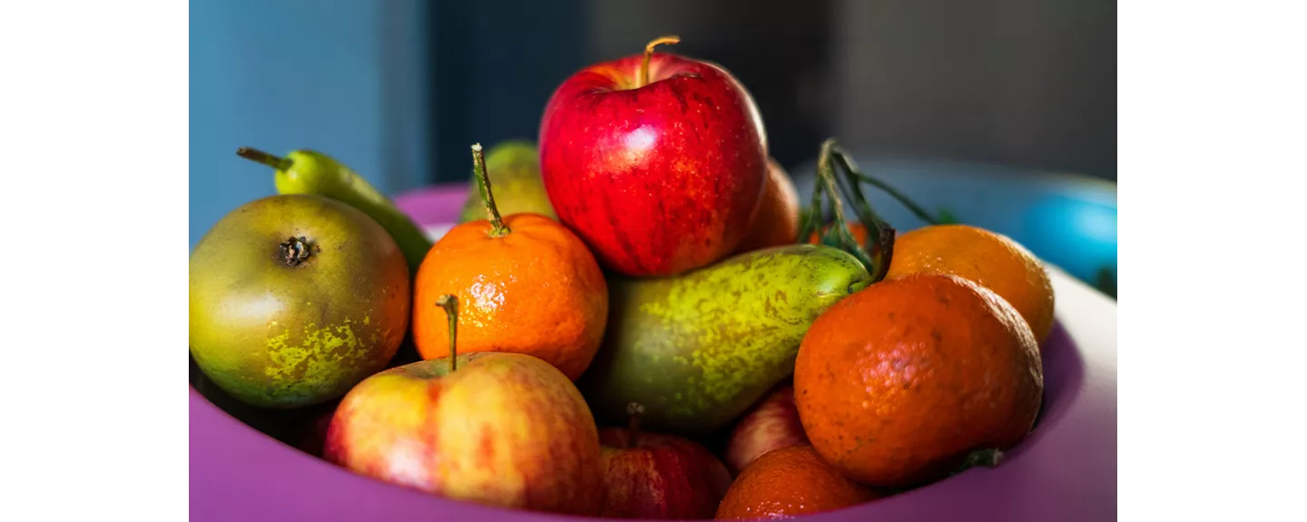 Manzanas con otras frutas representando que se deben guardar separadas