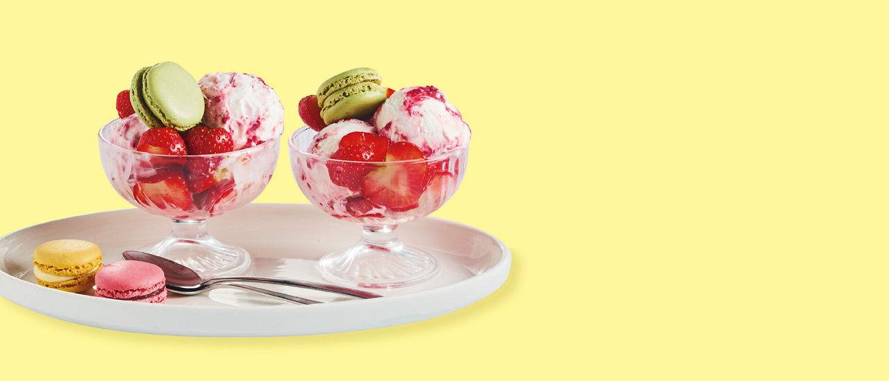 Yoghurtijscoupe met rood fruit en een macaron bij ALDI