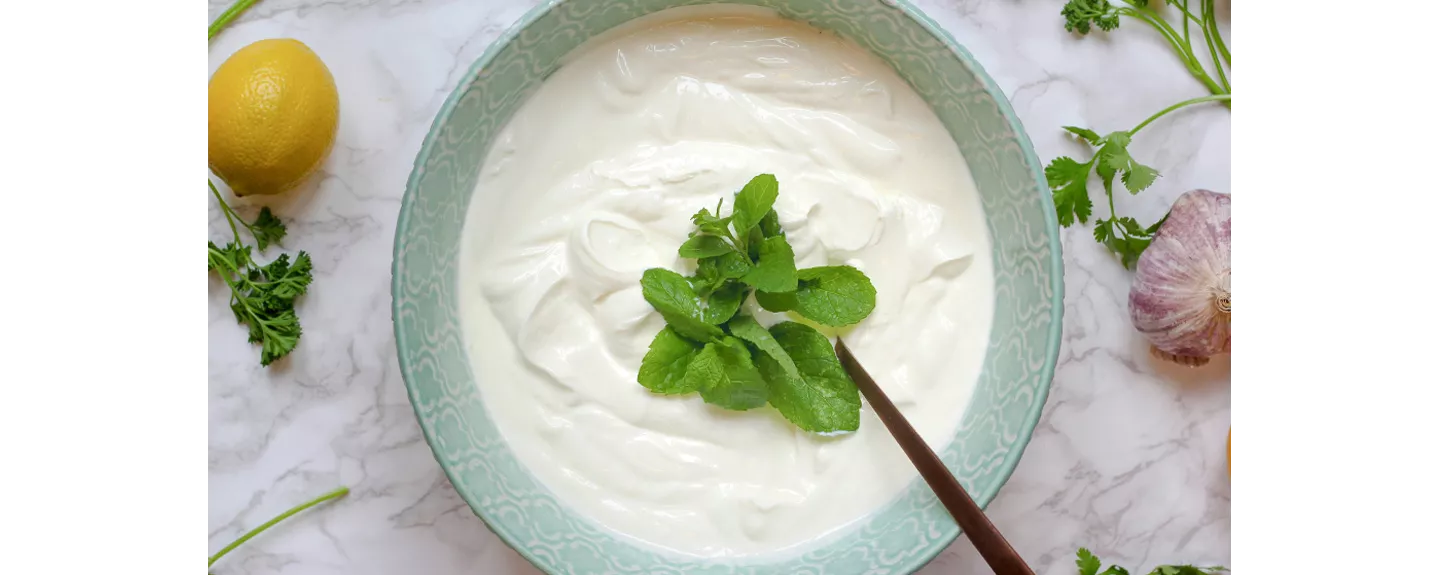 Cuenco de salsa de yogur con hojas de menta para acompañar ensaladas