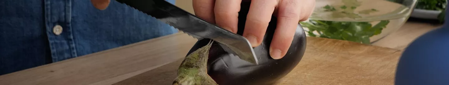 Persona cortando berenjena tabla madera