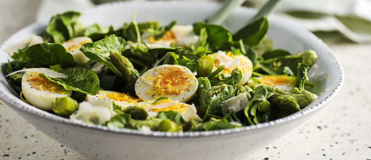 Lauwwarme salade van spinazie, groene asperges, verse kruiden en ei