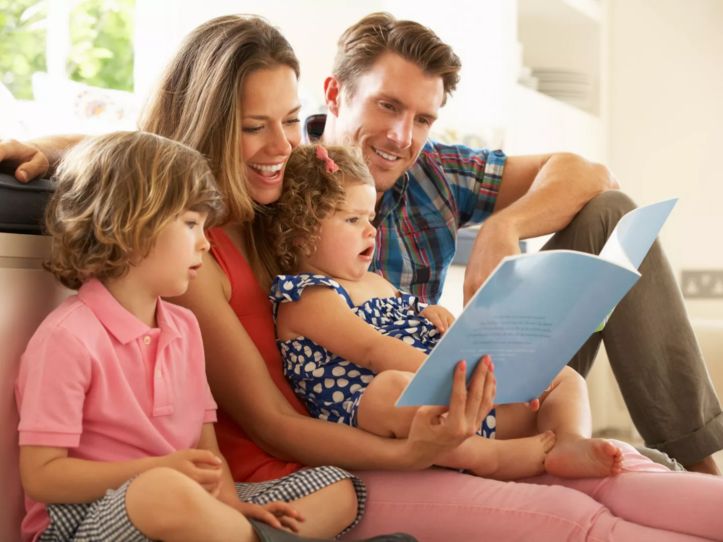 Familia leyendo libro infantil salón