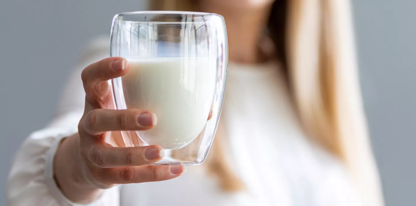 Persona mostrando vaso leche fermentada