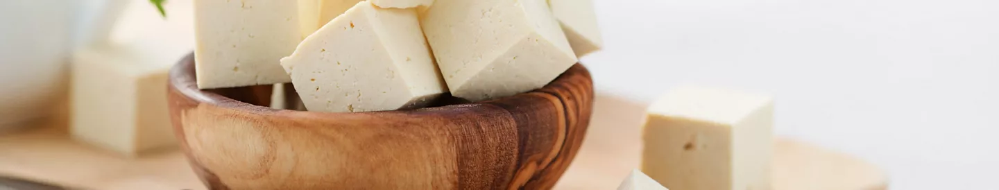 Cuenco dados tofu sobre tabla cortar