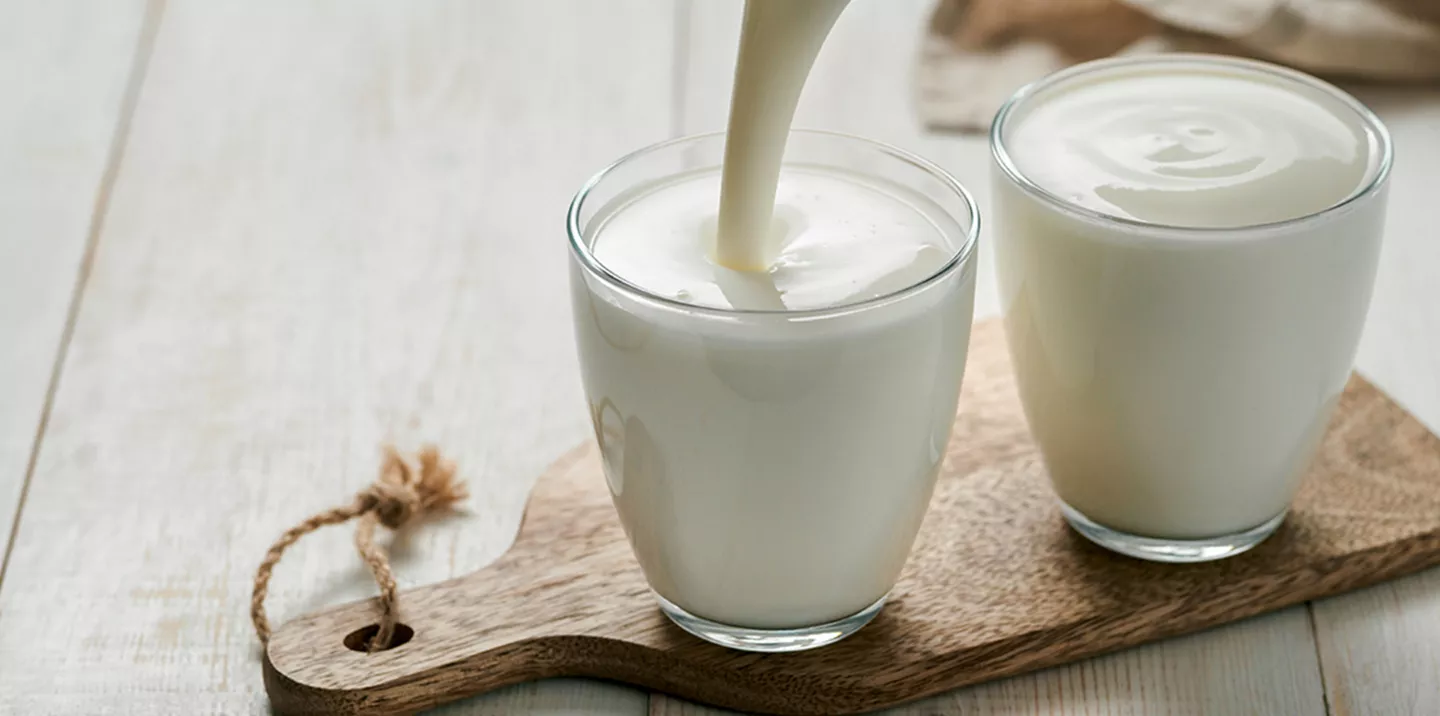 Dos vasos leche vidrio sobre madera cortar