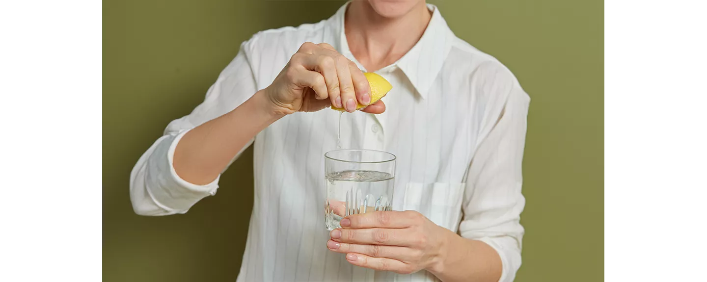 Una persona exprimiendo un limón que sirve para conservar manzanas cortadas
