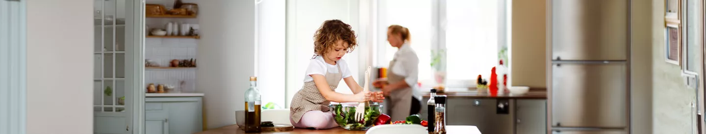 Niña cocinando una ensalada