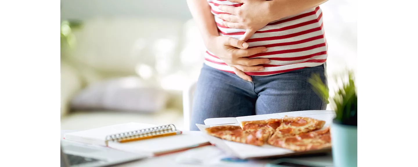 Mujer con molestias estomacales tras comer alimentos inflamatorios