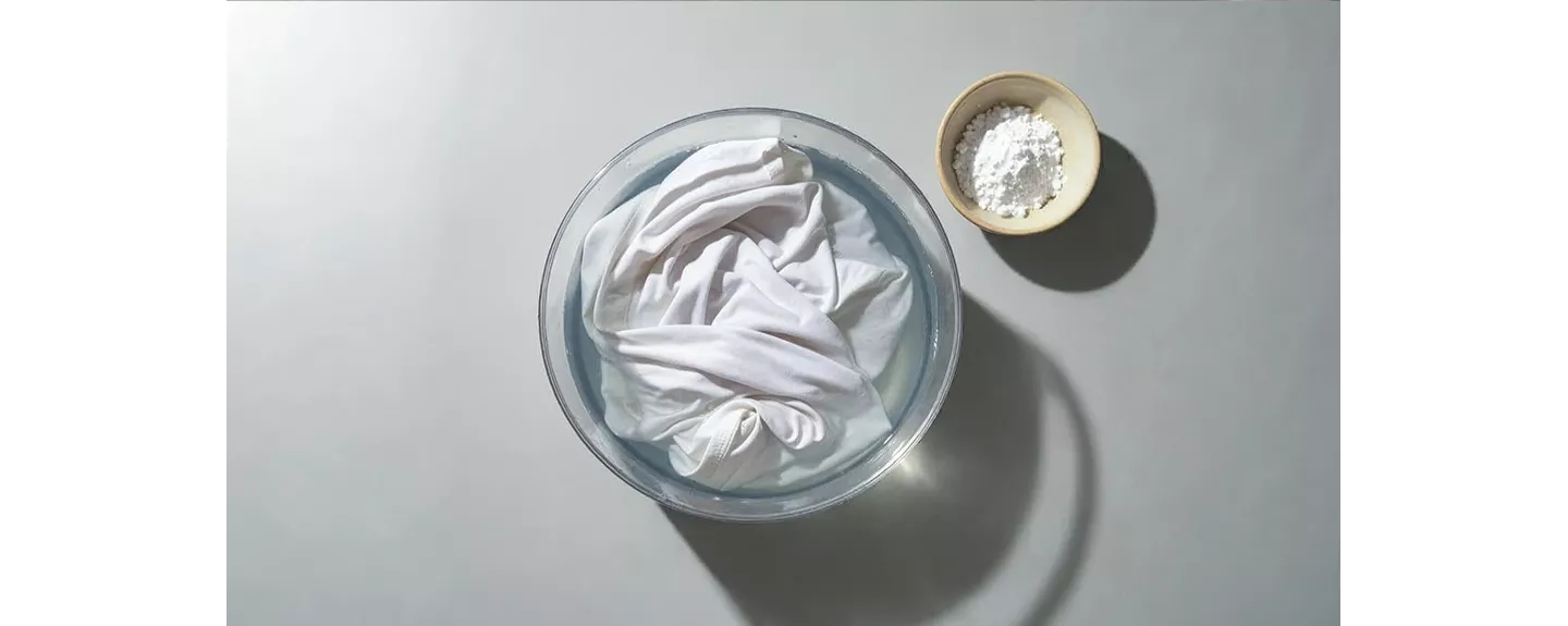 Camiseta manchada de maquillaje en agua y bicarbonato