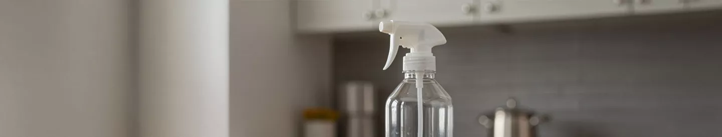 Botella de vinagre de limpieza con bayeta sobre encimera