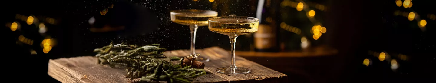Copas de espumoso sobre una mesa decorada con adornos navideños, ilustrando las diferencias entre cava y champán