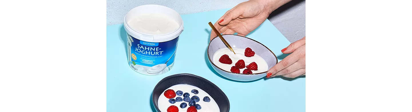 Person bereitet zwei Joghurtbowls zu.