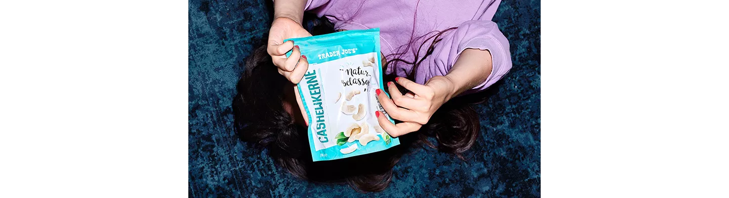 Eine Person hält Cashewkerne in die Kamera.