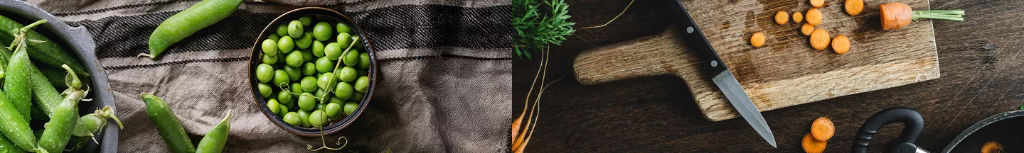 Gedünstete Edamame und eine in Scheiben geschnittenen Karotte auf einem dunklen Holzbrett.