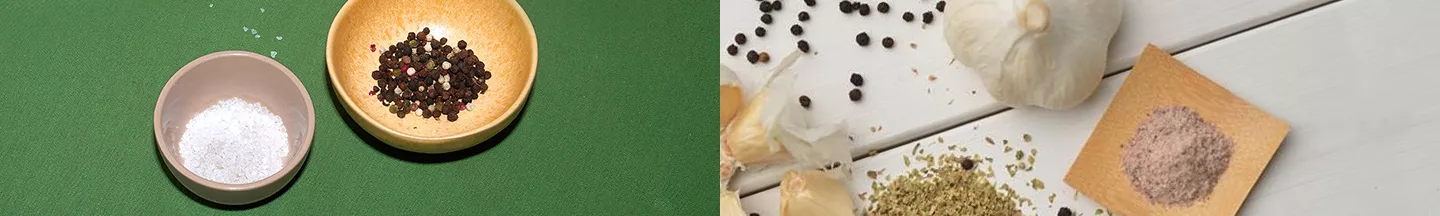 Links zwei Schalen mit Gewürzen darin, rechts ebenfalls verschiedene Gewürze, vor allem Knoblauch.