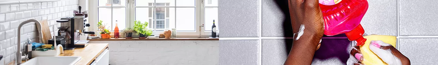 Weiße Küchenzeile mit hellem Holz, rechts daneben gibt eine Person Spüli auf einen Schwamm.