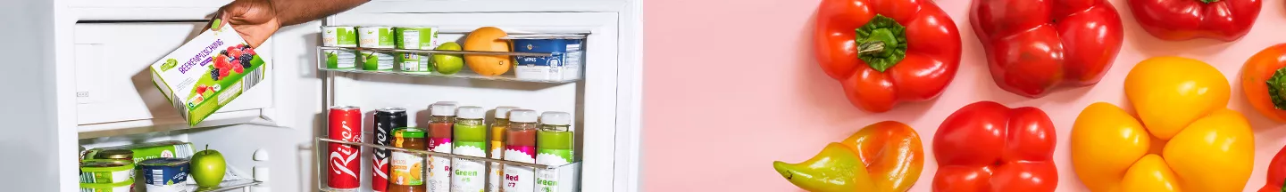 Packung Tiefkühl-Beerenmischung wird aus Kühlschrank genommen und Paprika auf rotem Tisch.