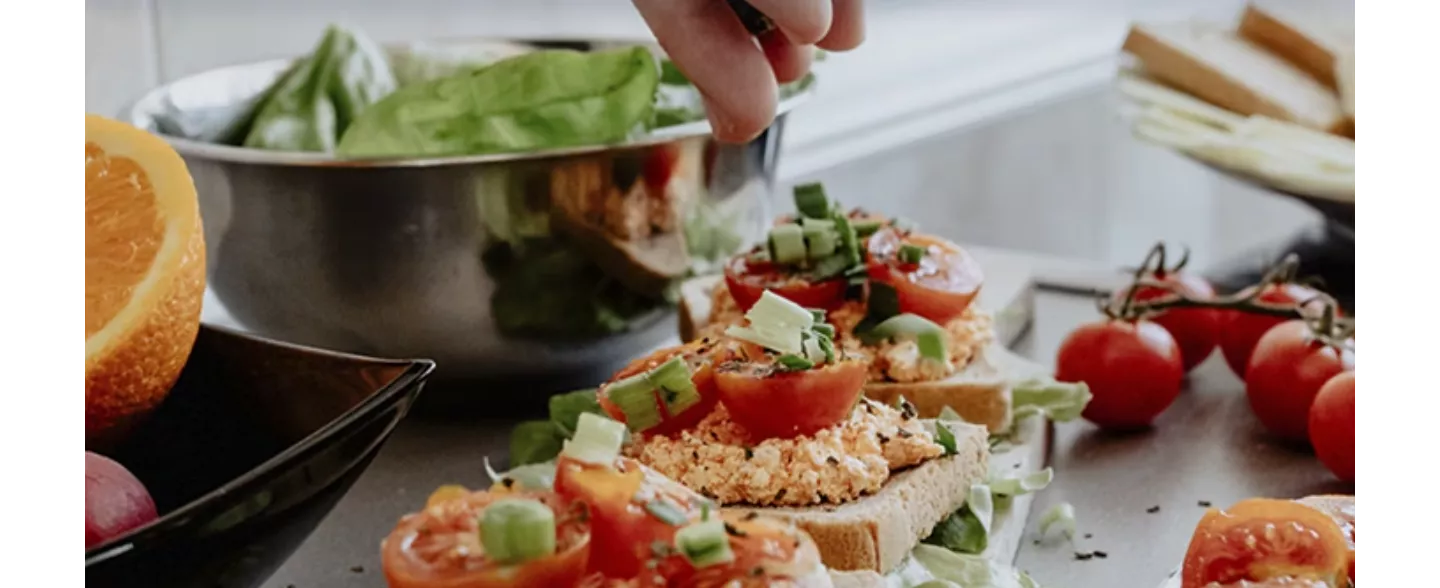 Bereiden van vega tapas broodjes met spread en tomaat