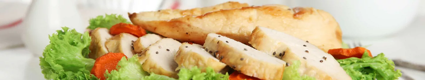 Pechuga de pollo fileteada sobre ensalada