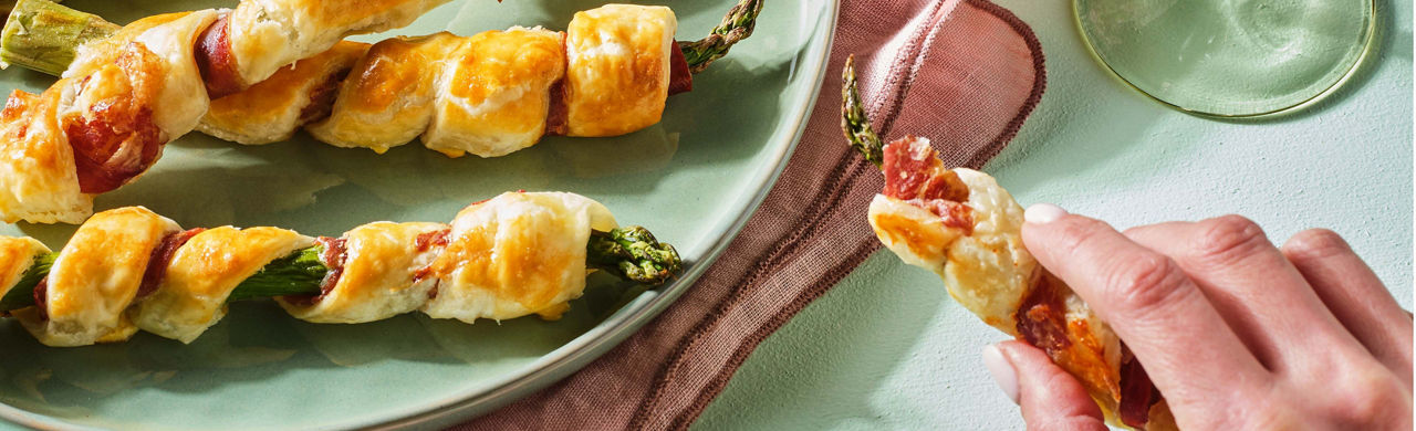 Bladerdeegstengsels met groene asperges en ibericoham