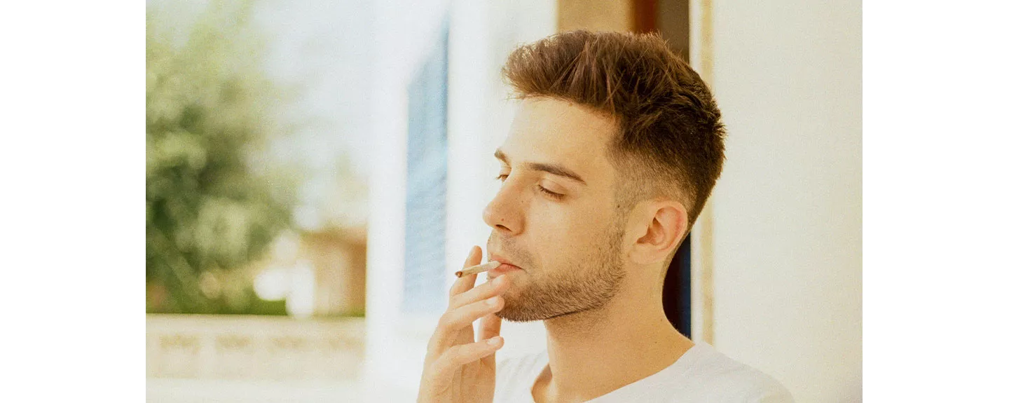 Hombre joven fumando, un factor que acelera el envejecimiento