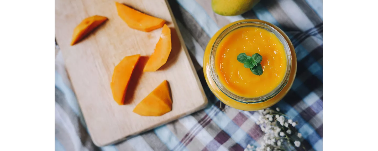 Bote de salsa de mango para ensaladas y mango en trozos sobre una tabla