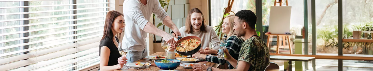 Estudiantes compartiendo pasta con ingredientes variados