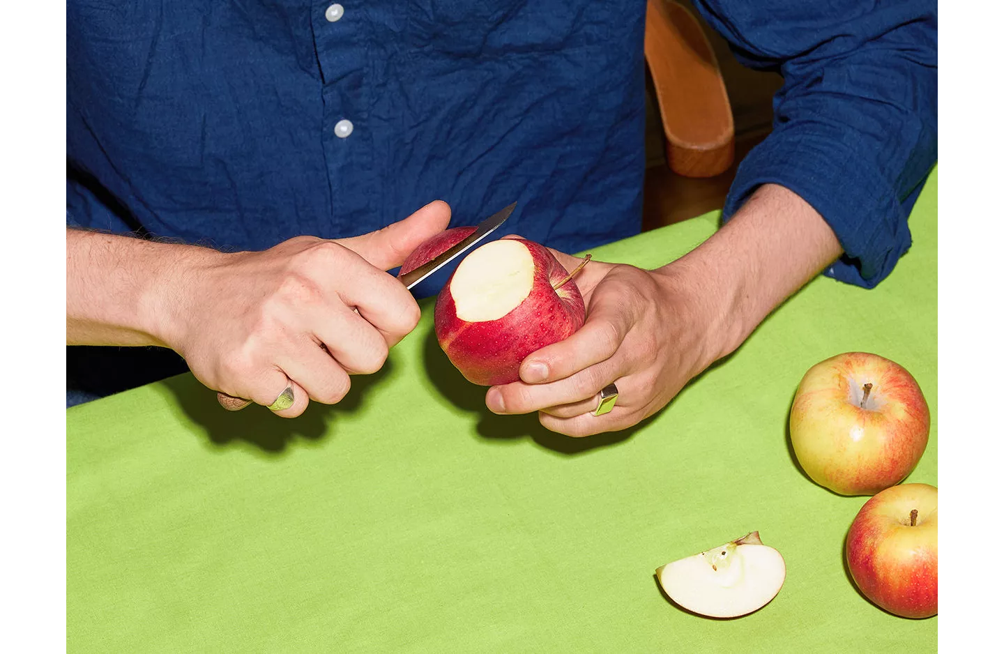 Person schneidet sich einen Apfel.