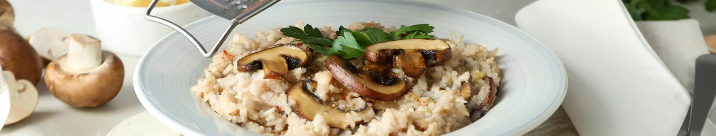 Persona rallando queso risotto comida italiana
