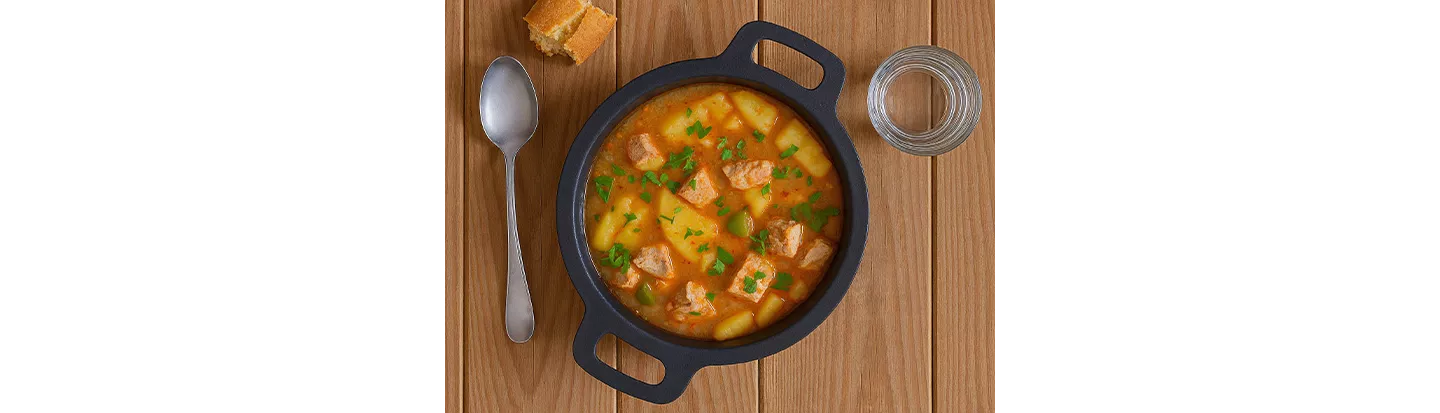 Plato de marmitako de bonito con patatas servido en la mesa